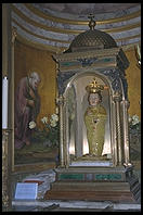 The Santa Bambino inside Santa Maria in Aracoeli, atop Rome's Capitol hill.  A 15th-century Franciscan monk carved this olive-wood figure of the Christ Child.  A sign explains that he lacked paint to decorate the idol so a saint came down and finished it for him.  While being transported on a boat, the Bambino was washed overboard but miraculously arrived at its intended destination on its own.  The idol is richly attired in fine fabrics and jewels, gifts from people who have been helped by its powers.  Sometimes the Bambino is carried to the beds of the gravely ill.  If it can help the sick person, the wooden lips turn purple.  If not, the lips turn pale.