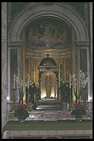 The Santa Bambino inside Santa Maria in Aracoeli, atop Rome's Capitol hill.  A 15th-century Franciscan monk carved this olive-wood figure of the Christ Child.  A sign explains that he lacked paint to decorate the idol so a saint came down and finished it for him.  While being transported on a boat, the Bambino was washed overboard but miraculously arrived at its intended destination on its own.  The idol is richly attired in fine fabrics and jewels, gifts from people who have been helped by its powers.  Sometimes the Bambino is carried to the beds of the gravely ill.  If it can help the sick person, the wooden lips turn purple.  If not, the lips turn pale.